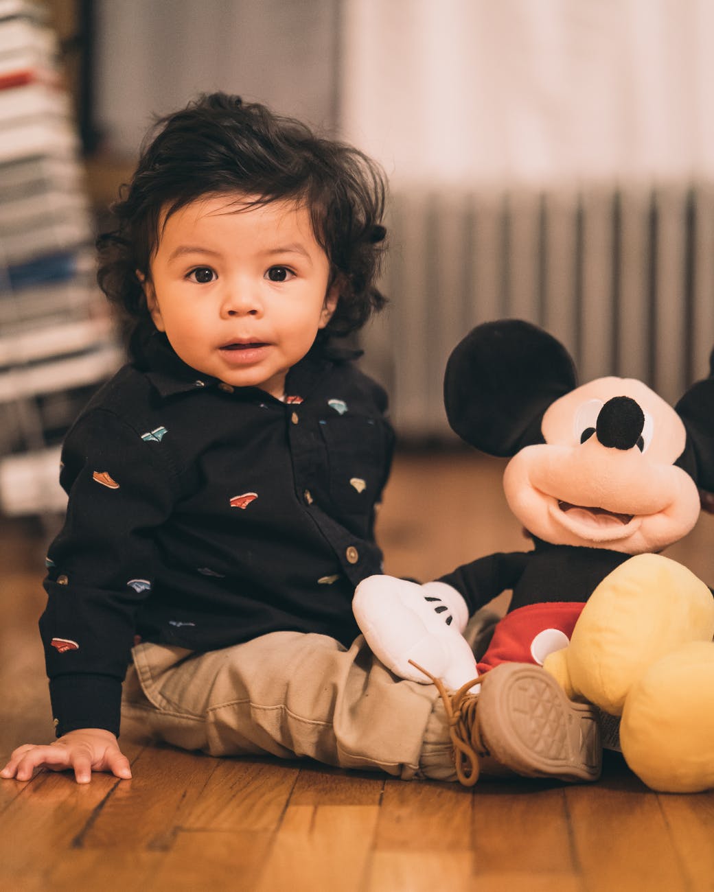 sitting child playing mickey mouse plush toy