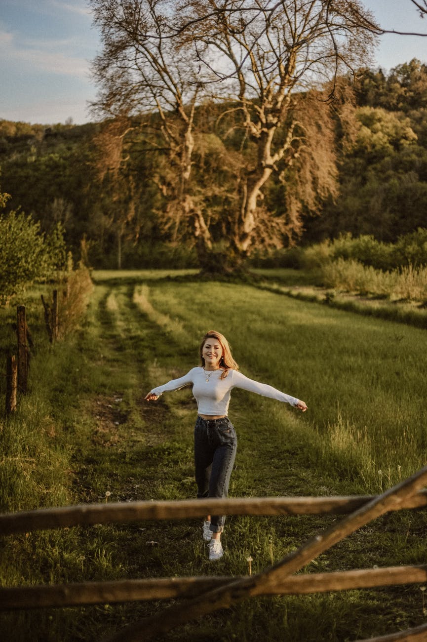 cheerful woman on grass lawn in countryside