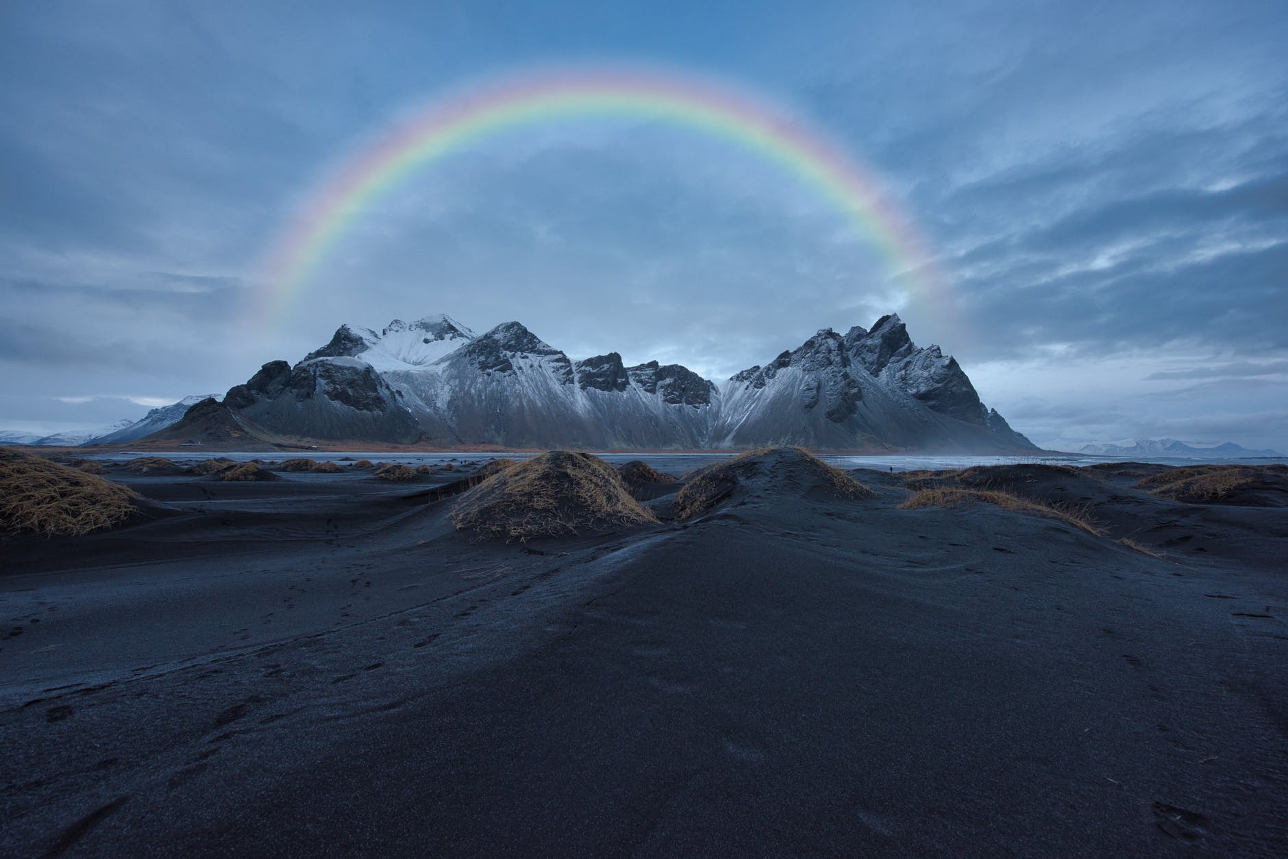 photo of mountain under cloudy sky